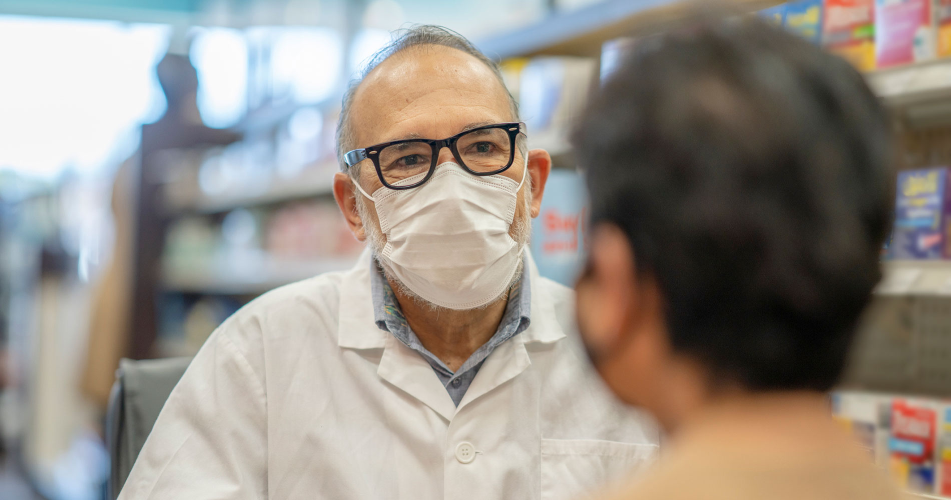 pharmacist in white coat conversing with a patient