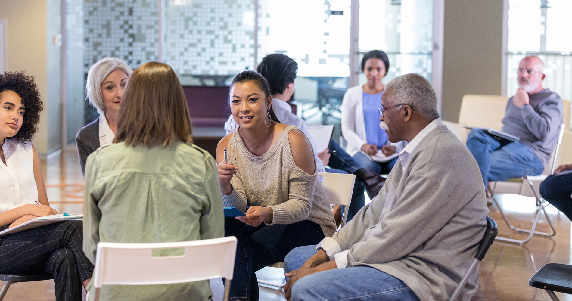 citizens in a circle having a discussion in a community center.