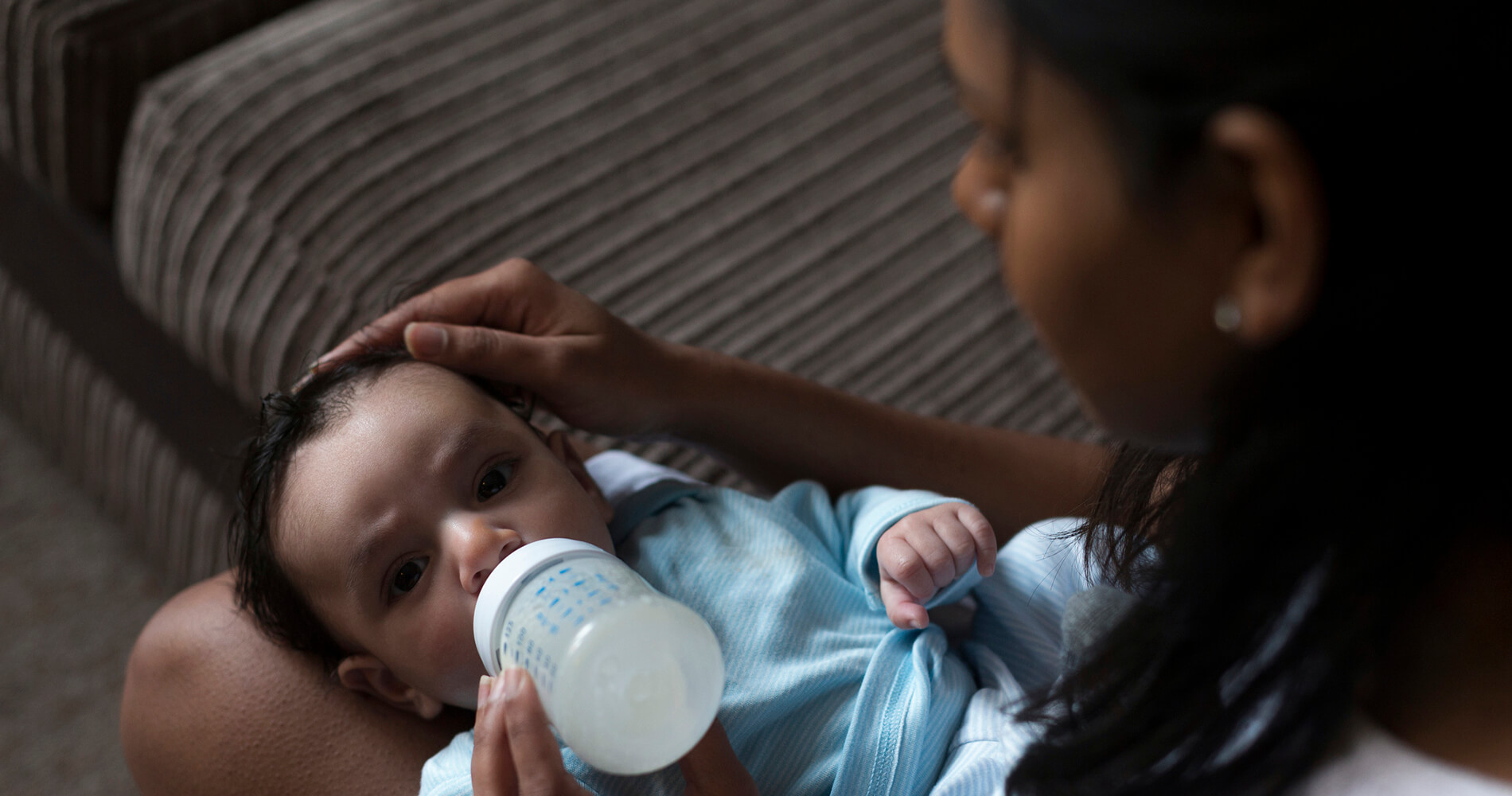 mother with newborn feeding from bottle